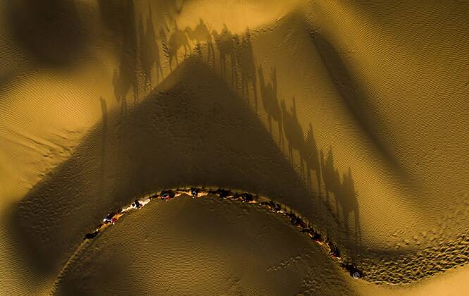 Bilder des Jahres 2019, News 10 Oktober (191028) -- BEIJING, Oct. 28, 2019 -- Aerial photo taken on Oct. 26, 2019 shows tourists riding camels to enjoy the desert scenery at Lop Nur People Village in Yuli County, northwest China s Xinjiang Uygur Autonomous Region. In the first three quarters of this year, Xinjiang received over 183.85 million tourists from home and abroad with a year-on-year increase of 40.9 percent, and saw a total tourism revenue of more than 304.6 billion yuan (about 43.1 billion U.S. dollars) with a year-on-year growth of 40.78 percent. ) XINHUA PHOTOS OF THE DAY ZhaoxGe 