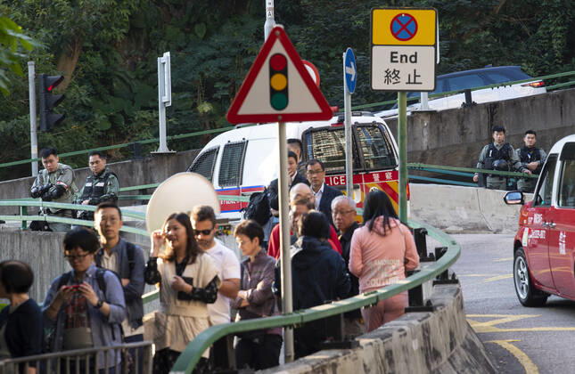 November 24, 2019, Hong Kong, Hong Kong SAR, China: Hong Kong Police tactical unit watch over the area.Hong Kong Chief Executive, CARRIE LAM, votes in the local council elections. Lam meets the press at Raymond College in Midlevels Central to cast her vote in an election predicted to show Hong Kongers true views following 5 months of protests. Hong Kong China - ZUMAr144 20191124_zap_r144_006 Copyright: xJaynexRussellx