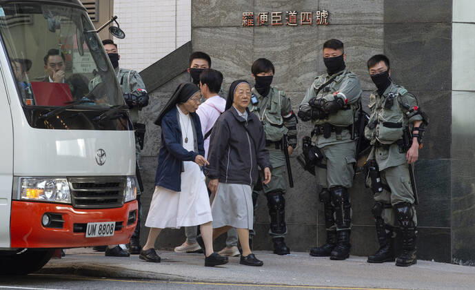 November 24, 2019, Hong Kong, Hong Kong SAR, China: Nuns walk past several Hong Kong Police tactical unit officers on the way to voting.Hong Kong Chief Executive, CARRIE LAM, votes in the local council elections. Lam meets the press at Raymond College in Midlevels Central to cast her vote in an election predicted to show Hong Kongers true views following 5 months of protests. Hong Kong China - ZUMAr144 20191124_zap_r144_012 Copyright: xJaynexRussellx