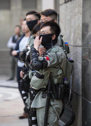 November 24, 2019, Hong Kong, Hong Kong SAR, China: Hong Kong Police tactical unit watch over the area.Hong Kong Chief Executive, CARRIE LAM, votes in the local council elections. Lam meets the press at Raymond College in Midlevels Central to cast her vote in an election predicted to show Hong Kongers true views following 5 months of protests. Hong Kong China - ZUMAr144 20191124_zap_r144_013 Copyright: xJaynexRussellx