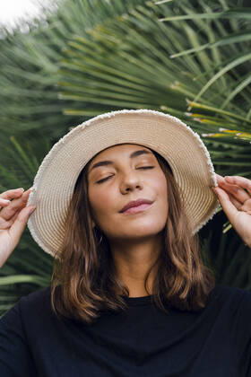 Creative Highlights Symbolfotos Portrait of young woman with eyes closed wearing summer hat model released Symbolfoto  AFVF04173