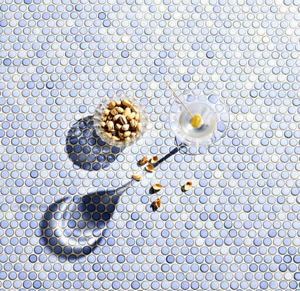 Directly above shot of pistachios and martini glass on blue patterned background  KSWF02072