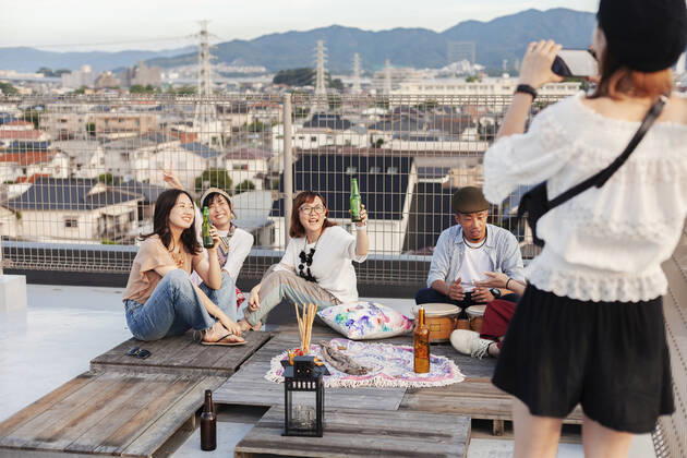 IMAGO Kreativ: Urbane Kultur - Sommer auf den Dächern Smiling group of young Japanese men and women on a rooftop in an urban setting. Smiling group of young Japanese men and women on a rooftop in an urban setting.  60077