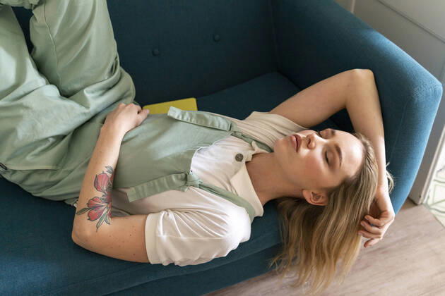 Creative Highlights Symbolfotos Portrait of young woman lying on couch with closed eyes model released Symbolfoto property released AFVF04484