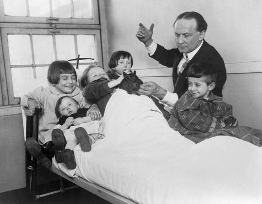 Harry Houdini and his rabbit entertain five hospitalized children. Ca. 1925. Courtesy Everett Collection PUBLICATIONXNOTxINxCANxCHNxFRAxITAxJPNxNORxPOLxRUSxESPxUKxUSA Copyright: xCourtesyxEverettxCollectionx HISL011 EC109