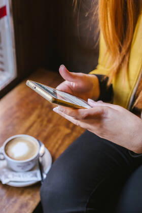 Crop view of young woman using smartphone in a coffee shop model released Symbolfoto property released  LJF01269