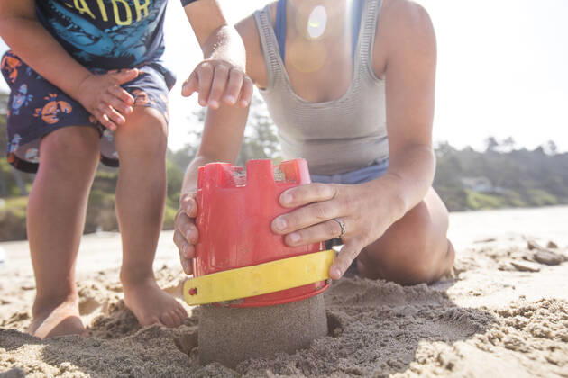 Low angle of mother and son building sand castle. Manzanita, OR, United States ,model released, Symbolfoto CR_JDIP200116A-282606-01