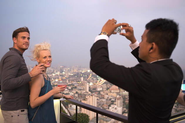 Romantic dinner. Banyan Tree Rooftop Vertigo & Moon Bar, Restaurant, , Bangkok , Thailand. View of the city, Vertigo Bar and Restaurant, roof of the Banyan Tree Hotel, at dusk Bangkok, Thailand, Asia. Reaching for the clouds at Vertigo and Moon Bar on the 61st floor of the Banyan Tree hotel is one of the best ways to end a long day in Bangkok. There is no lack of rooftop bars in town but Vertigo has always been amongst the favourites. With an unusual narrow and elongated shape, the entire top of the building is occupied by both the bar and the restaurant and gives the unusual impression of being aboard a spaceship in the sky. Located on Sathorn road, a very large busy avenue peppered with tall glass and metal skyscrapers and not far from the Lumpini park and Silom area, Banyan Tree is a name often associated with luxury. The hotel and its Copyright: xSergixReboredox SREB-DA2327
