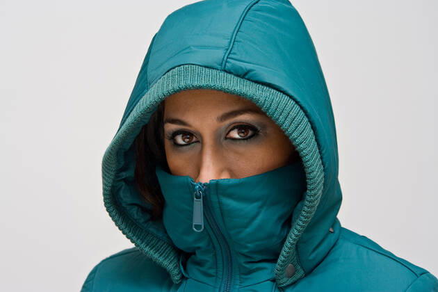 Young woman with green hood A young woman wearing a green winter coat using the hood to cover her head so that only her eyes are visible, isolated on white  Copyright: xphakimatax 619469