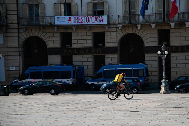 Italy: Turin lockdown 14th April 2020 An delivery man wering an safety mask in Piazza Castello in a deserted Turin on April 14, 2020 in Italy, during the country s lockdown aimed at curbing the spread of the COVID-19 infection, caused by the novel coronavirus. Turin Piedmont Turin Italy Copyright: AlbertoxGandolfo