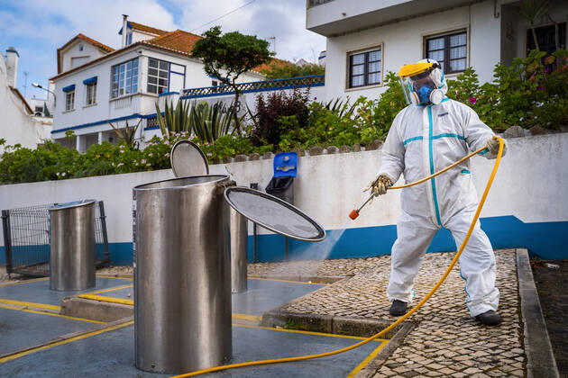 April 14, 2020, Ericeira, Portugal: An employee of the Ericeira parish council, equipped with the recommended protective materials, disinfects the recycling tanks with a solution based on hypochlorite (bleach)..The municipality of Mafra had 70 cases of COVID-19 pandemic. In order to prevent the spread of the virus, the Ericeira Parish Council perform weekly street disinfection. Ericeira Portugal - ZUMAs197 20200414_zaa_s197_171 Copyright: xHenriquexCasinhasx