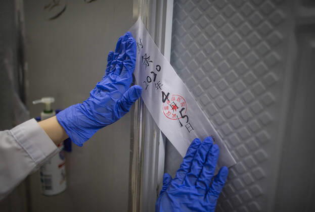 (200415) -- WUHAN, April 15, 2020 -- A nurse with Zhongnan Hospital of Wuhan University seals off a gate of Leishenshan (Thunder God Mountain) Hospital in Wuhan, capital of central China s Hubei Province, April 15, 2020. Wuhan Leishenshan (Thunder God Mountain) Hospital ceased operation in Wuhan on Wednesday as the coronavirus epidemic wanes. ) CHINA-HUBEI-WUHAN-LEISHENSHAN HOSPITAL-RETIRING (CN) XiaoxYijiu 