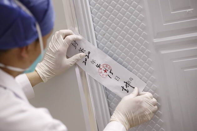 (200415) -- WUHAN, April 15, 2020 -- A nurse seals off a gate of Leishenshan (Thunder God Mountain) Hospital in Wuhan, capital of central China s Hubei Province, April 15, 2020. Wuhan Leishenshan (Thunder God Mountain) Hospital ceased operation in Wuhan on Wednesday as the coronavirus epidemic wanes. ) CHINA-HUBEI-WUHAN-LEISHENSHAN HOSPITAL-RETIRING (CN) ShenxBohan 