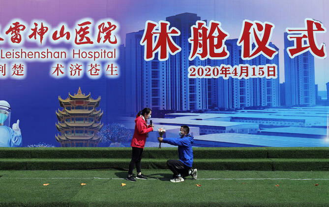 (200415) -- WUHAN, April 15, 2020 -- Hu Zhimin (R), a nurse with Zhongnan Hospital of Wuhan University, professes his love for his colleague Zeng Yingying, during the closing ceremony of Leishenshan (Thunder God Mountain) Hospital in Wuhan, capital of central China s Hubei Province, April 15, 2020. Wuhan Leishenshan (Thunder God Mountain) Hospital ceased operation in Wuhan on Wednesday as the coronavirus epidemic wanes. ) CHINA-HUBEI-WUHAN-LEISHENSHAN HOSPITAL-RETIRING (CN) ShenxBohan 