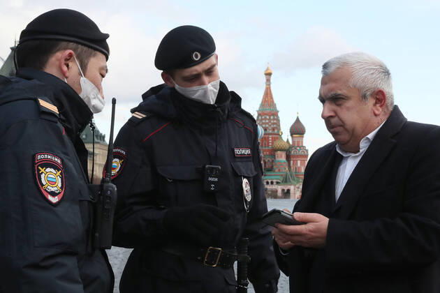 MOSCOW, RUSSIA - APRIL 15, 2020: Police officers check a man s documents in Red Square. Since 30 March 2020, Moscow has been on lockdown. Earlier, the Russian government announced a paid period off work for employed people and school holidays, which are expected to last till the end of April. On 13 April 2020, the Moscow government introduced a digital permit system aimed at further movement restrictions; from April 15, people need to apply for digital permits to travel on public transport or a personal vehicle around the city. As of 15 April 2020, Russia has reported more 24,500 confirmed cases of the novel coronavirus infection, with more than 14,800 confirmed cases in Moscow. Sergei Savostyanov TASS  TS0D5E45