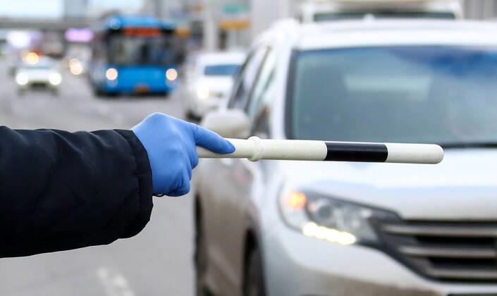 MOSCOW, RUSSIA - APRIL 15, 2020: A traffic police officer carries out ID checks on Leningradskoye Shosse Motorway at the entrance to Moscow during the pandemic of the novel coronavirus disease (COVID-19). Traffic police have set up checkpoints around the city to stop vehicles and see if drivers have permission to travel during the lockdown. On 13 April 2020, the Moscow government introduced a digital permit system aimed at further restricting movement. Under the new scheme, which becomes mandatory from 15 April, people need to apply for permits to travel on a vehicle or public transport around the city. Earlier, on 11 April, the Moscow government restricted vehicles registered outside Moscow Region from entering the Russian capital. Since 30 March 2020, Moscow has been on lockdown. As of 15 April 2020, Russia has reported more than 21,100  TS0D5D53