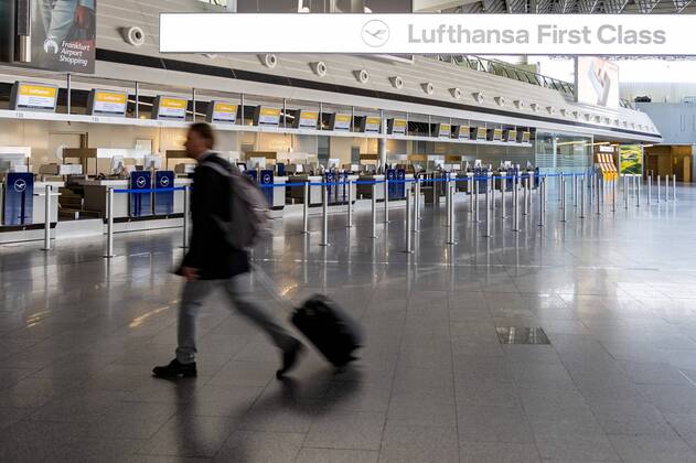 Frankfurt am Main, Flughafen Frankfurt , 15.04.2020, Flughafen Frankfurt am Main, an der leeren Schalterhalle der Lufthansa läuft ein Mann mit Rollkoffer vorbei Frankfurt am Main Flughafen Frankfurt Hessen Deutschland