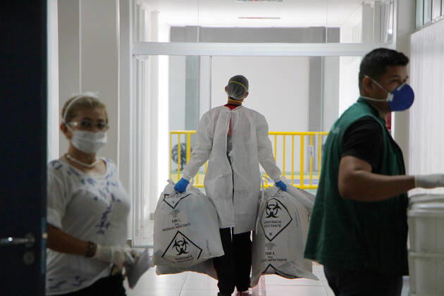 MANAUS, AM - 15.04.2020: HOSPITAL DE CAMPANHA GILBERTO NOVAES - Employee collects toxic waste. Municipal Campaign Hospital Gilberto Novaes, set up to receive patients with Covid-19. The hospital was created in a partnership between the City of Manaus and Samel and is located in an old school in the north of the city. x1904659x  SandroxPereira