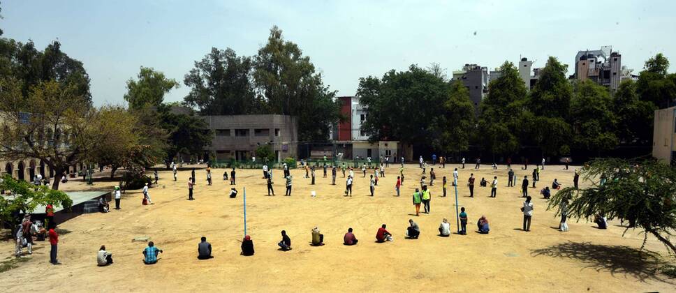 NEW DELHI, INDIA - APRIL 15: Stranded migrant workers and homeless people queue to collect food during the lockdown, at Sunlight colony, Seema Puri area on April 15, 2020 in New Delhi, India. (Photo by Sonu Mehta Hindustan Times) India Extends Nationwide Coronavirus Lockdown Until May 3