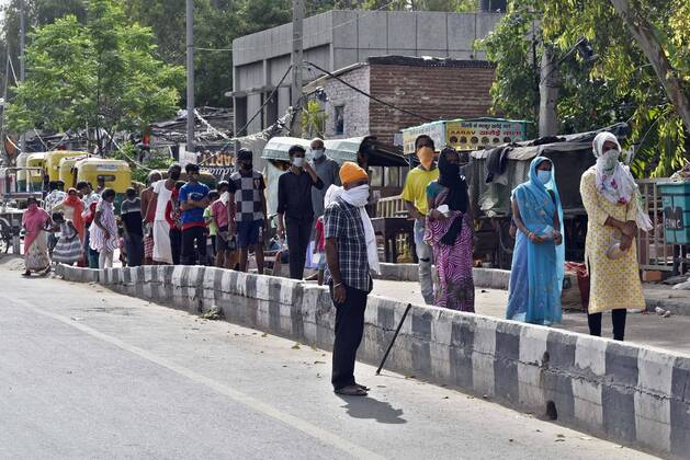 NEW DELHI, INDIA - APRIL 15: People stand queue for food distribute by Baba Gorakhnath Dhuna Ashram workers at slum people at NH 24 near mother dairy, on day twenty two of the 21-day nationwide lockdown on April 15, 2020 in New Delhi, India. (Photo by Sanjeev Verma Hindustan Times) Government Provide Food To Homeless And Poor Amid Lockdown To Prevent Covid-19