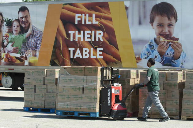 April 15, 2020, Austin, Texas, USA: Central Texas Food Bank volunteers work to load 28-pound boxes of staples into vehicles during a food giveaway in east Austin. Almost 2,500 families picked up boxes in response to extensive coronavirus pandemic job losses and general Texas economic fallout Austin USA - ZUMAd150 20200415_znp_d150_038 Copyright: xBobxDaemmrichx