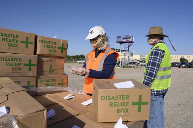 April 15, 2020, Austin, Texas, USA: Central Texas Food Bank volunteers work to load 28-pound boxes of staples into vehicles during a food giveaway in east Austin. Almost 2,500 families picked up boxes in response to extensive coronavirus pandemic job losses and general Texas economic fallout Austin USA - ZUMAd150 20200415_znp_d150_039 Copyright: xBobxDaemmrichx