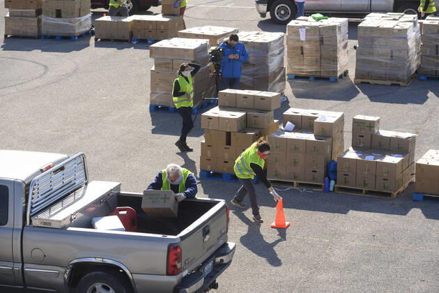April 15, 2020, Austin, Texas, USA: Central Texas Food Bank volunteers work to load 28-pound boxes of staples into vehicles during a food giveaway in east Austin. Almost 2,500 families picked up boxes in response to extensive coronavirus pandemic job losses and general Texas economic fallout Austin USA - ZUMAd150 20200415_znp_d150_041 Copyright: xBobxDaemmrichx