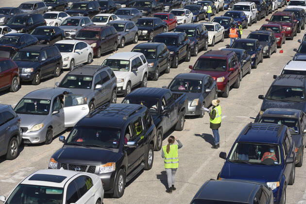 April 15, 2020, Austin, Texas, USA: Central Texas Food Bank volunteers survey people in long lines of cars as they later receive 28-pound boxes of staples during food giveaway in east Austin. Almost 2,500 families picked up boxes in response to extensive coronavirus pandemic job losses and general Texas economic fallout Austin USA - ZUMAd150 20200415_znp_d150_044 Copyright: xBobxDaemmrichx