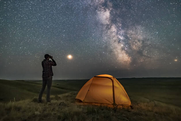 IMAGO Creative: Ende des Sommers A person poses for a scene in Grasslands National Park, Saskatchewan, Canada, of stargazing with binoculars under the Milky Way on a dark moonless night. Grasslands is perfect for stargazing as it is a Dark Sky Preserve and the horizon is vast and unobstructed. Mars is bright to the left and the galactic centre is to the south at right. The view is overlooking the Frenchman River Valley. Copyright: AlanxDyer StocktrekxImages ADY200702S