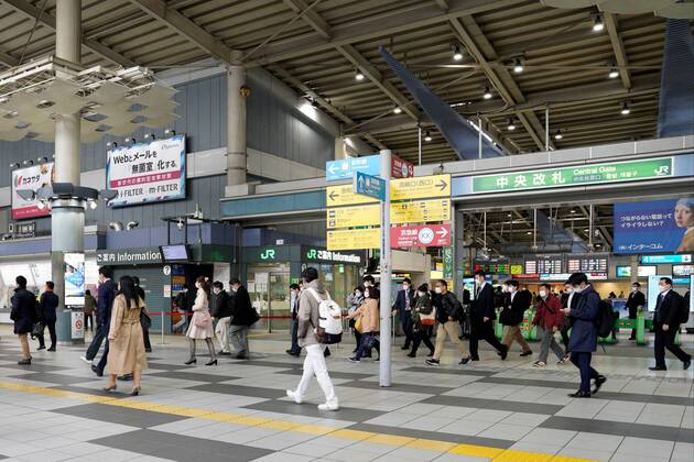 People wearing protective masks walk through a train station during the morning rush hour in Tokyo, Japan on April 16, 2020, amid the state of emergency due to the spread of the novel coronavirus.  (125388344)