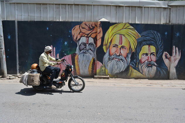 April 16, 2020, Prayagraj, Uttar Pradesh, India: Prayagraj: A milkman use mask as he passes near a graffiti during a nationwide lockdown imposed as a preventive measure against the spread of the COVID-19 coronavirus in Allahabad Prayagraj India - ZUMAv115 20200416_zap_v115_004 Copyright: xPrabhatxKumarxVermax