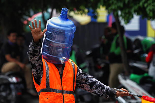 News Bilder des Tages Wearing Gallons for Face Shield amid the spread of COVID-19 in Indonesia - 16 April 2020. A traffic control volunteer wearing unique face shields from used gallons in Yogyakarta, Wednesday, April 16, 2020. Ali Akbar (52) wearing unique face shield when managing traffic amid the spread of Coronavirus (COVID-19) disease. (Photo by Devi Rahman INA Photo Agency imago images) 