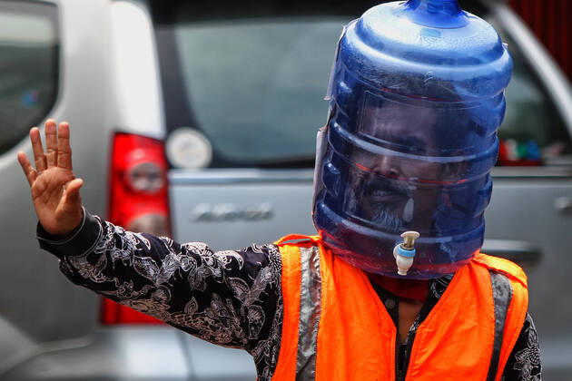 Wearing Gallons for Face Shield amid the spread of COVID-19 in Indonesia - 16 April 2020. A traffic control volunteer wearing unique face shields from used gallons in Yogyakarta, Wednesday, April 16, 2020. Ali Akbar (52) wearing unique face shield when managing traffic amid the spread of Coronavirus (COVID-19) disease. (Photo by Devi Rahman INA Photo Agency imago images) 