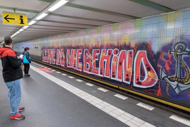 April 16, 2020: People can be seen next to a large graffiti by the artist group 1UP with the text Leave no one behind on the wall of the underground station KurfuerstenstraoÅ¸e in Berlin. The hashtag used is recalling the debate about the politics, practices and events surrounding the European border regime and about migration movements and is often used by groups advocating humanitarian rights for refugees. - ZUMAs172 20200416_zap_s172_003 Copyright: xJanxScheunertx