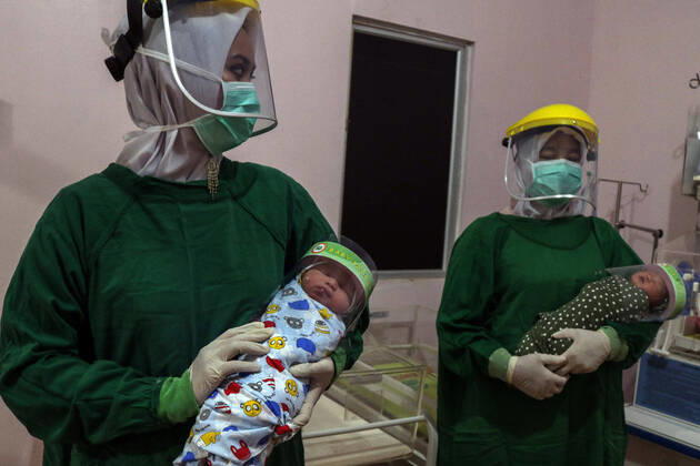 Newborn Baby Wearing Face Shield in Indonesia - 16 April 2020. Two Indonesian nurses hold a newborn baby wearing a face shield at a hospital in Bireuen District, Aceh Province, Indonesia, Thursday, April 16, 2020. Wearing protective face shields was effort prevent the spread of coronavirus Covid-19 . (Photo By Aziz Abdi INA Photo Agency imago images) 