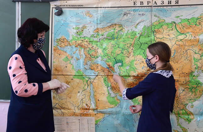 PRIMORYE TERRITORY, RUSSIA - APRIL 16, 2020: A pupil in a face mask shows the Black Sea on a map during a geography lesson at No 8 Comprehensive School in the village of Nezhino, some 40 km north of Vladivostok. After moving to online schooling due to the COVID-19 pandemic, educational institutions in the Primorye Territory are switching back to classroom teaching, with underfilled schools being the first to welcome pupils. Yuri Smityuk TASS  TS0D5F23