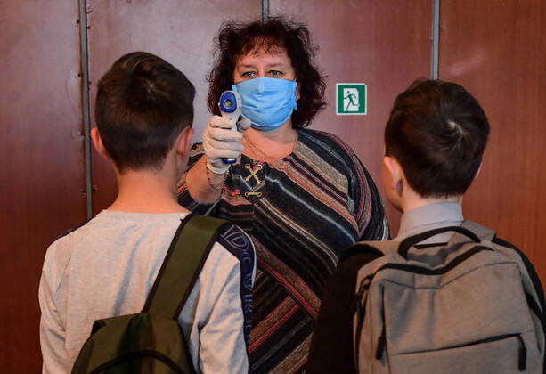 PRIMORYE TERRITORY, RUSSIA - APRIL 16, 2020: The headmistress screens pupils temperature at the entrance to No 8 Comprehensive School in the village of Nezhino, some 40 km north of Vladivostok. After moving to online schooling due to the COVID-19 pandemic, educational institutions in the Primorye Territory are switching back to classroom teaching, with underfilled schools being the first to welcome pupils. Yuri Smityuk TASS  TS0D5F2F