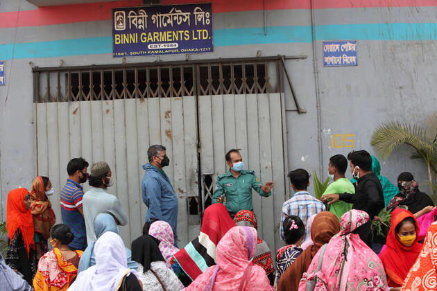April 16, 2020: A police officer talk to the garment workers to solve the problem in front of their factory gate, while they demonstrate to demand for due wages in South Kamlapur, Dhaka, Bangladesh; during the nationwide lockdown of the coronavirus (Covid-19) pandemic. Their garment factory had been closed for a period of time since 25, March2020 for their health issue due to the coronavirus pandemic. - ZUMAa186 20200416_zip_a186_008 Copyright: xShafayetxHossainxApollox