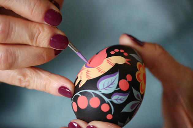 MOSCOW, RUSSIA - APRIL 16, 2020: Artist Iya Tokareva paints a wooden Easter egg Gorodets-style at her home studio; Gorodets painting, one of the traditional Russians handicrafts, originated in the middle of XIX century in the town of Gorodets, the Nizhny Novgorod Region. Anton Novoderezhkin TASS  TS0D5FDF