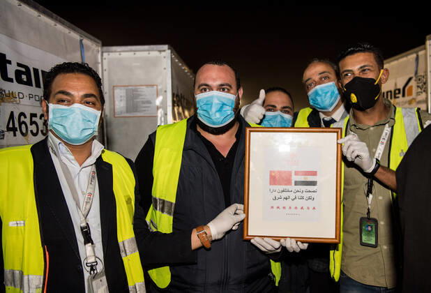(200416) -- CAIRO, April 16, 2020 -- Workers pose for photos after finishing transfering medical supplies from China in Cairo International Airport, Egypt, April 16, 2020. Egypt received on Thursday the first batch of China s anti-coronavirus materials including 20,000 N95 masks, 10,000 protective suits and 10,000 testing kits for COVID-19. When receiving the materials at the airport, Mohamed Shawky, undersecretary of Egyptian Health Ministry, expressed his appreciation to the Chinese side for the aid and its support for Egypt amid the ongoing difficult conditions. ) EGYPT-CAIRO-CHINESE AID-COVID-19 WuxHuiwo