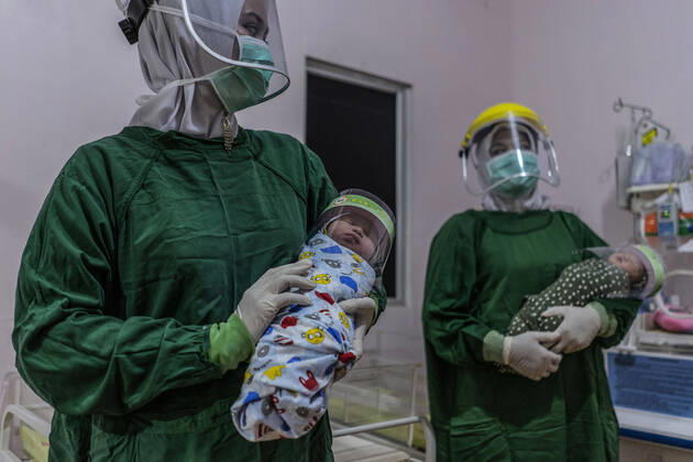 April 16, 2020, Bireuen, Aceh, Indonesia: Nurse wears a protective gear holds a newborn baby wearing a face shield as a protective measure amid fears of coronavirus disease COVID-19 at a hospital in Bireuen, Aceh province. Latest reports of COVID-19 cases, Indonesian confirms 5.516 positive cases, 548 recovered with 496 deaths. Bireuen Indonesia - ZUMAm250 20200416_zip_m250_004 Copyright: xZikrixMaulanax