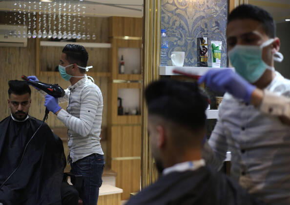 Daily Life at Barber in Southern Gaza Strip, Palestine amid Coronavirus Outbreak - 16 April 2020. A Palestinian barber wearing a face mask and a medical glove with his hand as a precautionary measure against Coronavirus (COVID-19), sterilizes his tools before cutting the customer s hair in Khan Yunis, southern Gaza Strip, Palestine, April 16, 2020. (Photo by Yousef Masoud INA Photo Agency imago images) 