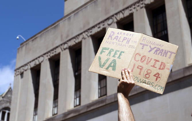 A person participates in a protest organized by the group ReOpen Virginia calling on an end to the Virginia stay at home order put in place to limit the spread of COVID-19, on the grounds of the Virginia State Capitol in Richmond on Thursday, April 16, 2020. The group is calling for Gov. Ralph Northam to end Executive Order 53 with bans gathers of over 10. Photo Kevin Dietsch  WAP20200416307 KEVINxDIETSCH