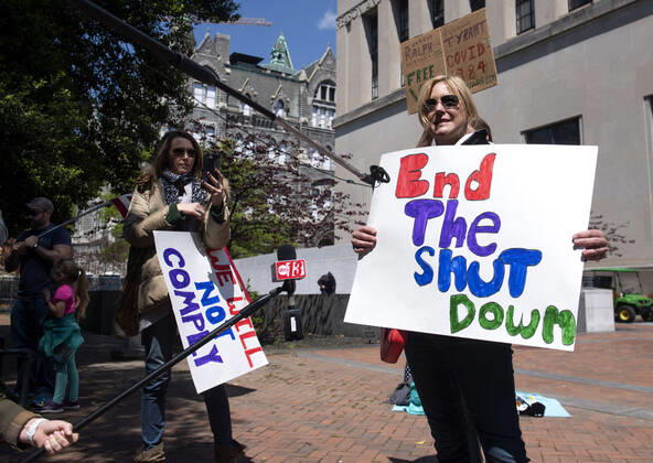 A person participates in a protest organized by the group ReOpen Virginia calling on an end to the Virginia stay at home order put in place to limit the spread of COVID-19, on the grounds of the Virginia State Capitol in Richmond on Thursday, April 16, 2020. The group is calling for Gov. Ralph Northam to end Executive Order 53 with bans gathers of over 10. Photo Kevin Dietsch  WAP20200416308 KEVINxDIETSCH