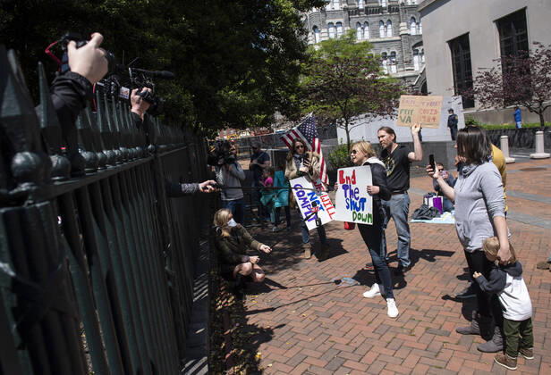 People participate in a protest organized by the group ReOpen Virginia calling on an end to the Virginia stay at home order put in place to limit the spread of COVID-19, on the grounds of the Virginia State Capitol in Richmond on Thursday, April 16, 2020. The group is calling for Gov. Ralph Northam to end Executive Order 53 with bans gathers of over 10. Photo Kevin Dietsch  WAP20200416309 KEVINxDIETSCH