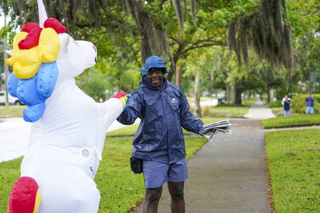 April 16, 2020, Tampa, Florida, USA: Corey Jurgensen greets Wesley Benjamin with a fist bump while she was out running while wearing an inflatable unicorn costume. Jurgansen says she does it to bring others joy during this time of isolation but finds it therapeutic for herself as well to run through her Seminole Heights neighborhood wearing a silly costume. Thursday, April 16, 2020 in Tampa. Tampa USA - ZUMAs70_ 20200416_zan_s70_029 Copyright: xMarthaxAsencioxRhinex