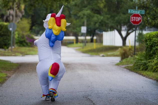 April 16, 2020, Tampa, Florida, USA: Corey Jurgensen has been wearing an inflatable unicorn costume during runs several times a week to cheer up others during this time of isolation but finds it therapeutic for herself as well to run through her Seminole Heights neighborhood wearing a silly costume. Thursday, April 16, 2020 in Tampa. Tampa USA - ZUMAs70_ 20200416_zan_s70_035 Copyright: xMarthaxAsencioxRhinex