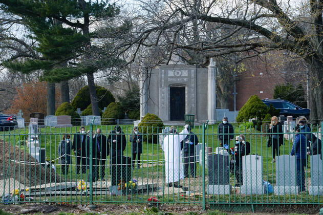 April 16, 2020, New York Queens, USA: Funeral in the time of Coronavirus. Priest praying at coronavirus patient s funeral and all family members wearing mask. The COVID-19 death toll in the NYC is 7,844 and 118,302 confirmed cases. 04 16 20. New York Queens St Joseph Cemetery. New York Queens USA - ZUMAs252 20200416_znp_s252_001 Copyright: xMarcusxSantosx
