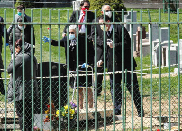 April 16, 2020, New York Queens, USA: Funeral in the time of Coronavirus. Priest praying at coronavirus patient s funeral and all family members wearing mask. The COVID-19 death toll in the NYC is 7,844 and 118,302 confirmed cases. 04 16 20. New York Queens St Joseph Cemetery. New York Queens USA - ZUMAs252 20200416_znp_s252_020 Copyright: xMarcusxSantosx