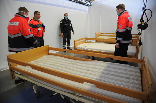 Die Sporthalle In den Fliesen in Saarlouis wird am Mittwoch (15.04.2020) wegen der Corona Krise zu einem Versogungszentrum umgebaut. Ingsgesamt 105 Betten werden in den kommenden Tagen von Hilfsorganisationen aufgestellt. Die Hilfskräfte von DRK, Malteser, THW, DRLG, BRH und der Feuerwehr Wadgassen bringen unter anderem Betten und Nachttische in die Sporthalle, wo diese dann aufgestellt und zum Teil aufgebaut werden müssen. Einige Betten kommen aus saarländischen Pflegeheimen. Heute werden 54 Pflegebetten aufgebaut. Geplant sind Dusch- und Toilettencontainer, die voraussichtlich morgen geliefert und angeschlossen werden. Wir sind lieber gut auf den Notfall vorbereitet , so Andreas Schorn, Mitarbeiter der Unterstützungsgruppe vom DRK Saarlouis.